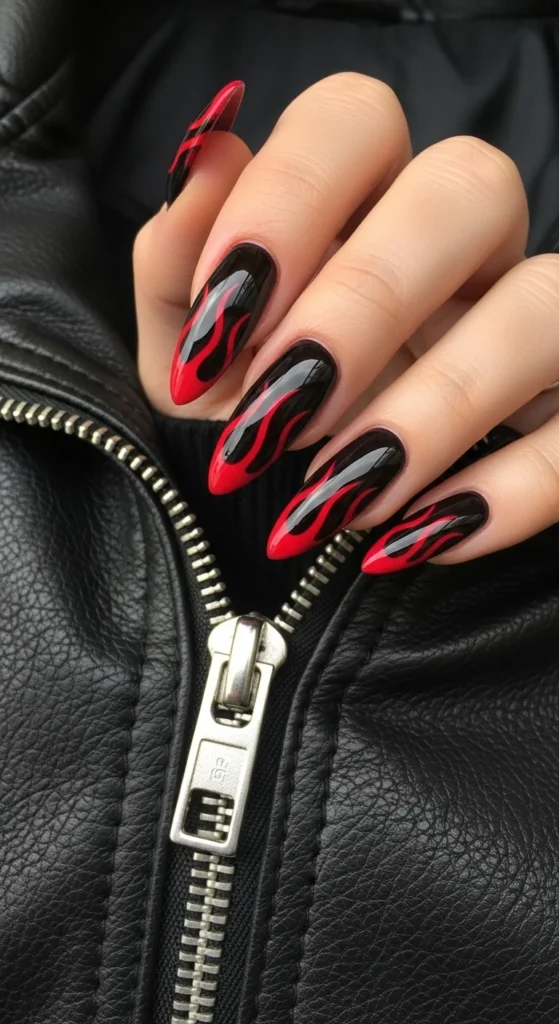 Black cherry almond nails with red flame tips adjusting leather jacket zipper.