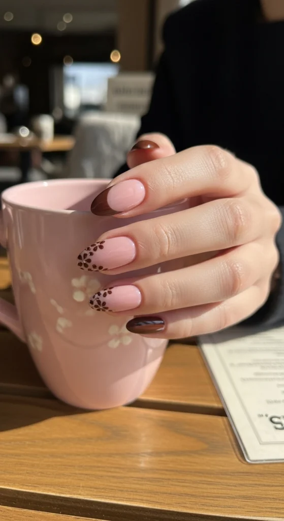 21 Fall Nails Inspiration 2026! Chic Trendy Autumn Manicures 9 Chocolate brown French tip almond nails with petal accents on a blurred café table background, playful yet chic.
