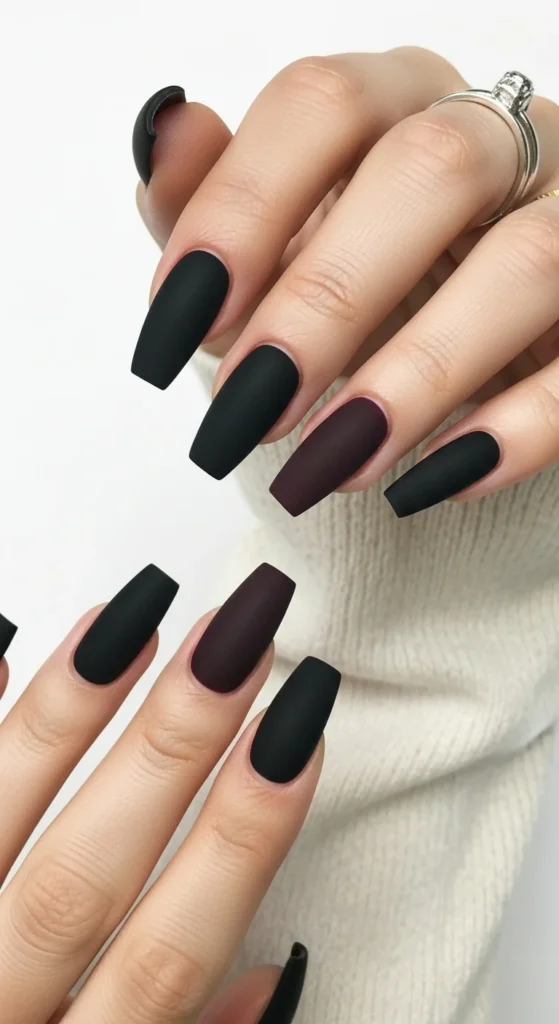 How to Shape Your Nails Like a Pro (Round, Almond, Coffin & More) 7 A close-up, top-down shot of a single hand showcasing beautifully manicured coffin/ballerina-shaped nails. The nails are painted in a chic matte black or a deep plum.