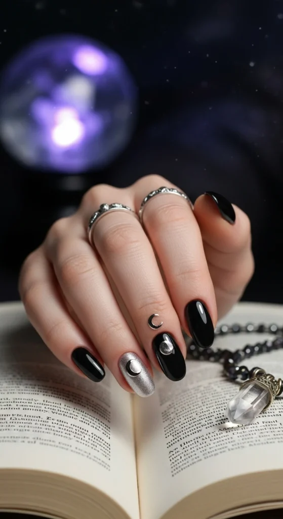  Jet black almond nails with metallic silver crescent moons, mystical celestial Halloween nail design. 