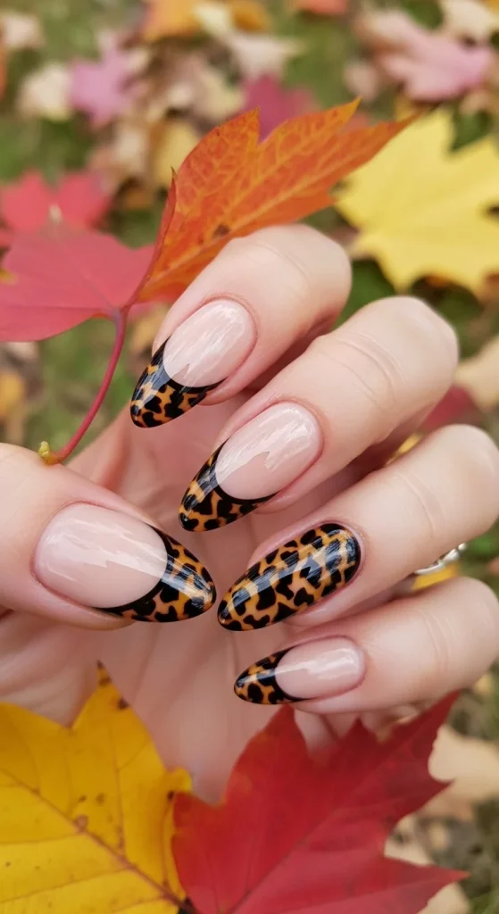 Black Fall Nails 2026: 19 Trendy Designs You’ll Love 13 Almond nude nails with tortoiseshell-effect black tips, autumn background.