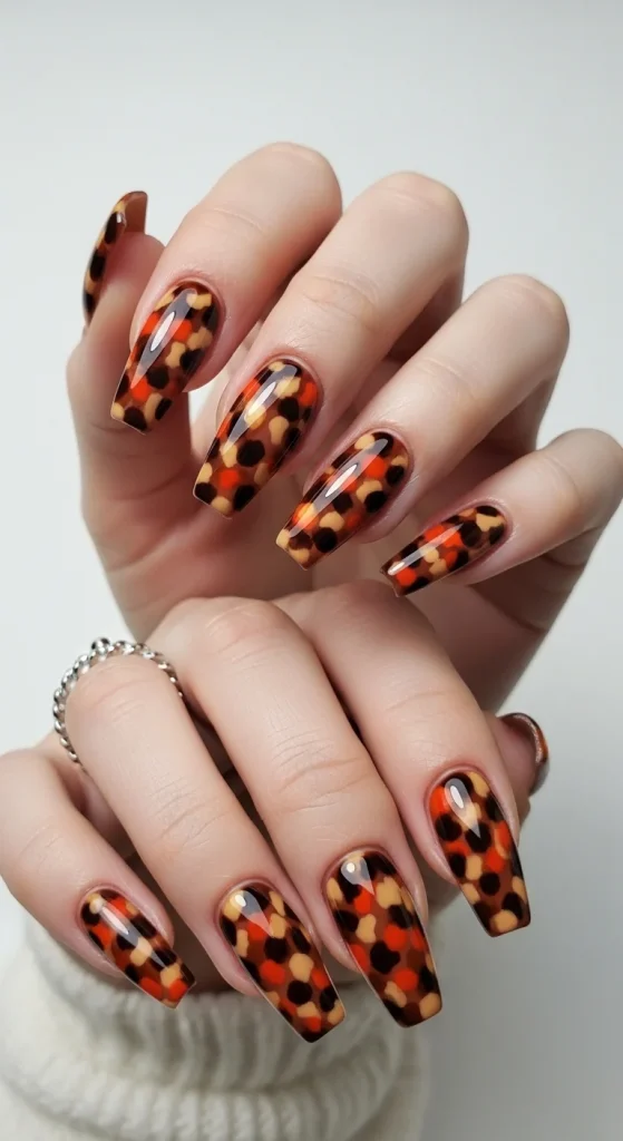 Burnt orange tortoiseshell coffin nails, trending fall 2025.