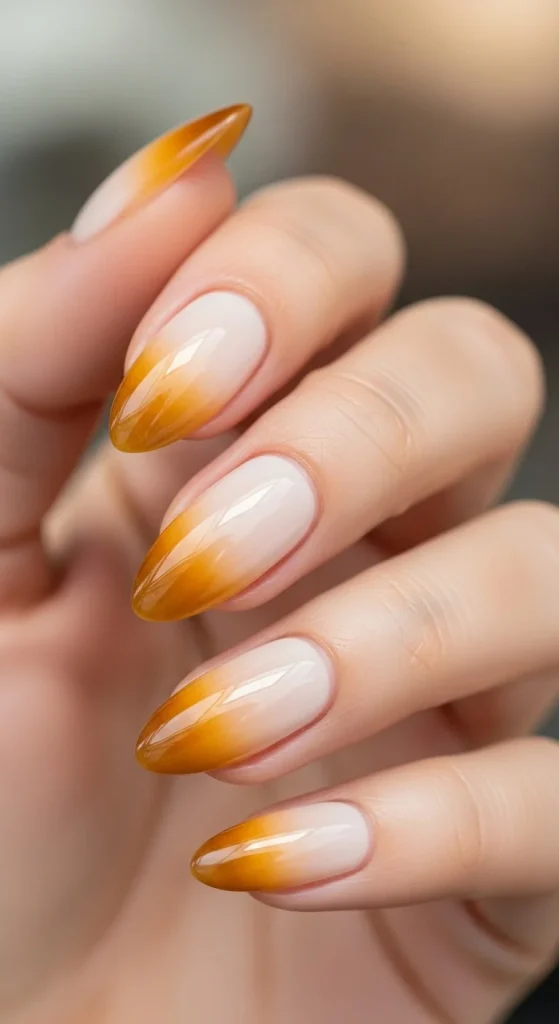 Almond nails with ombré fade from ivory to golden amber