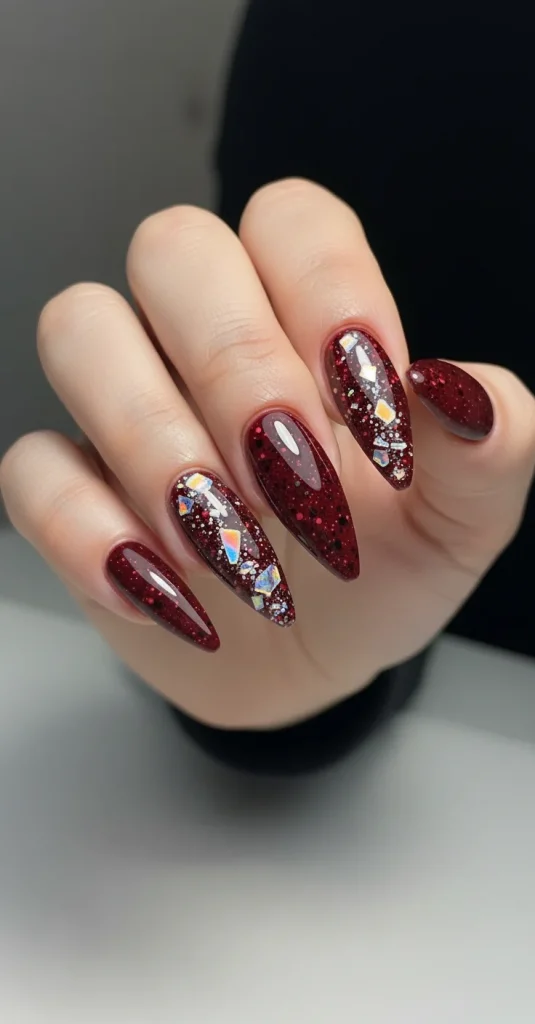 Crystal shard blood splatter nails — burgundy base with foil shards and pigment splatter.