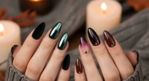 Elegant almond-shaped dark fall nails with mixed moody designs and autumn background.