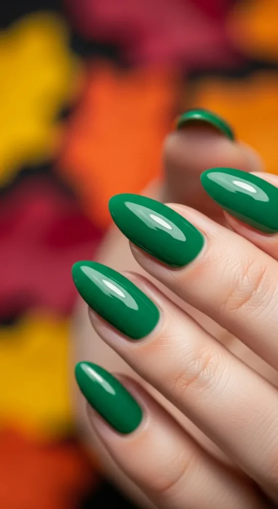 Almond nails in glossy emerald green polish.
