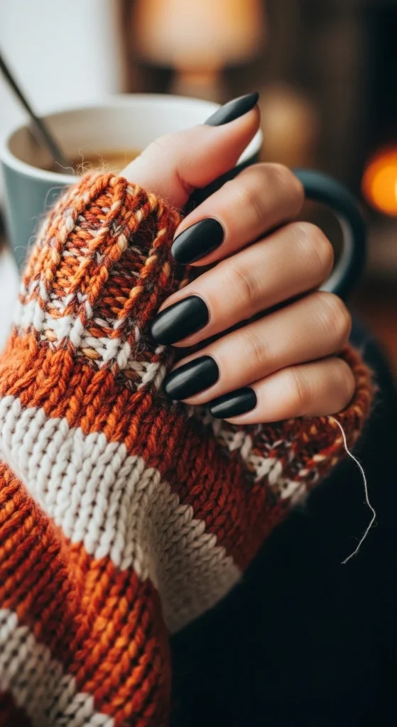 Black Fall Nails 2026: 19 Trendy Designs You’ll Love 6 Short oval matte black nails, cozy sweater aesthetic.