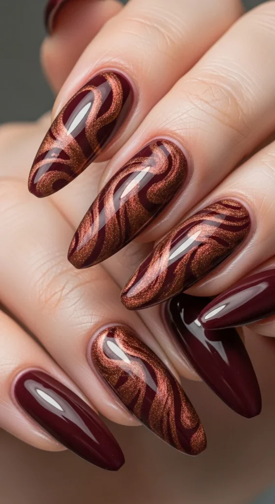 Glossy burgundy nails with cinnamon shimmer accents