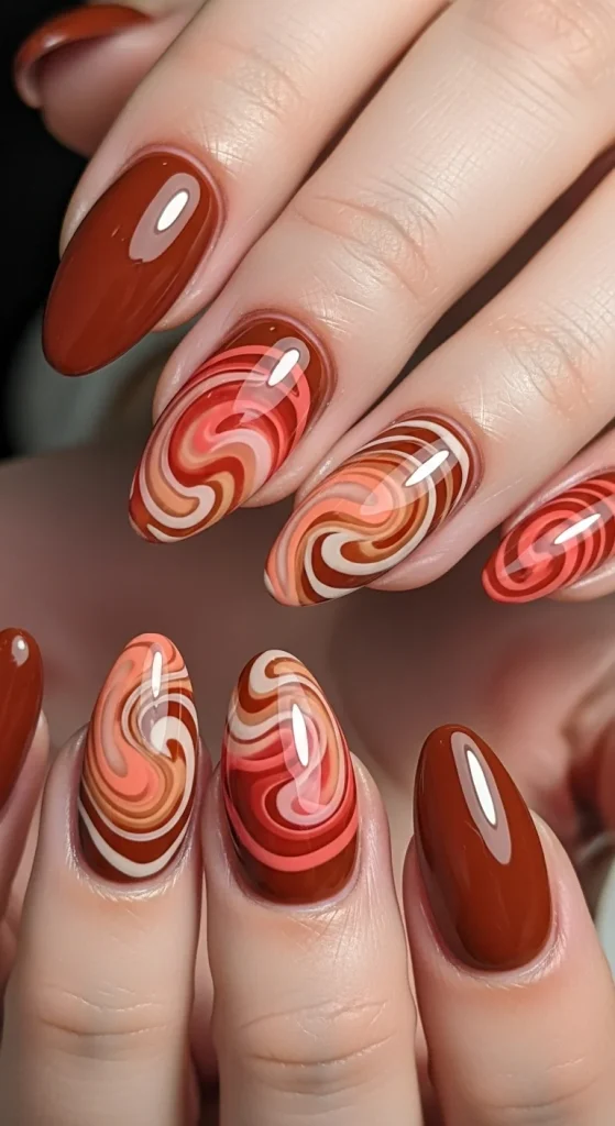 Warm Fall Nail Designs 2026: Earth Tone Manicure Ideas You’ll Love 20 Rust gradient swirl design on rounded nails with glossy finish