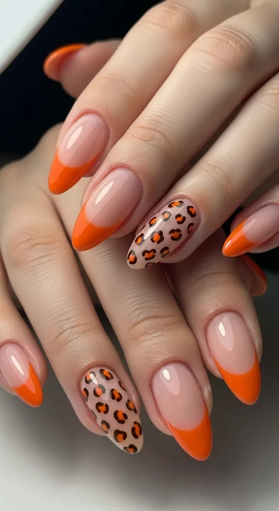 Pumpkin French tip nails with leopard accents for Halloween 2025.