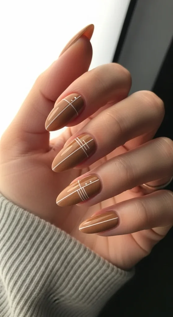 Camel-beige nails with ultra-fine white lines — soft and minimal festive style.