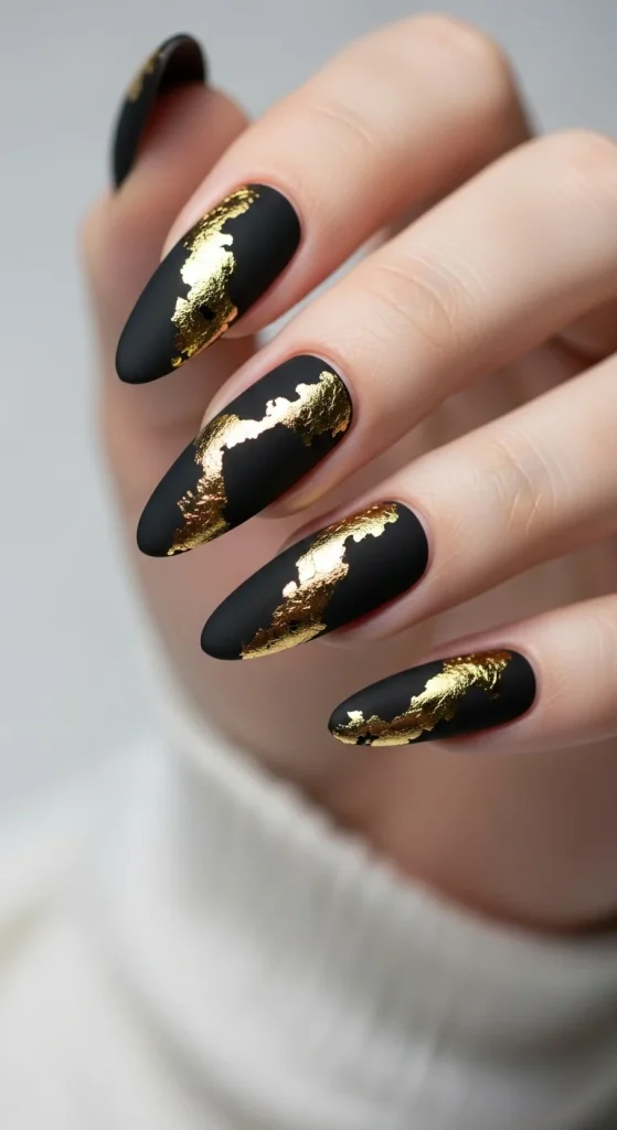Black nails with metallic gold foil accents