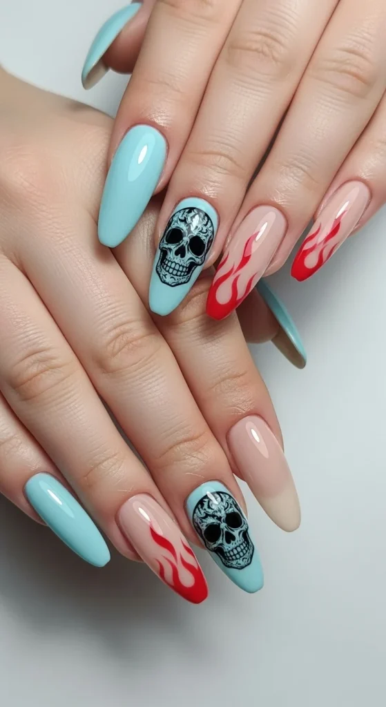 Minimal Halloween flame and skull nails with nude and pastel blue base, glossy finish, and subtle red flame accents with tiny skull art on almond nails.