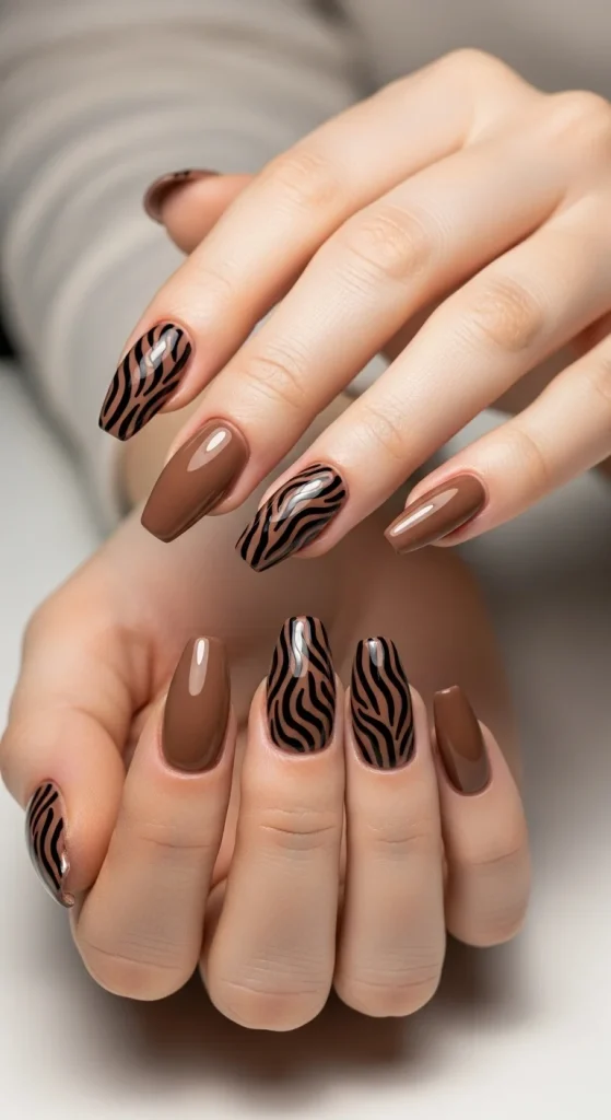 Mocha brown gel nails with black zebra print design, chic and bold.