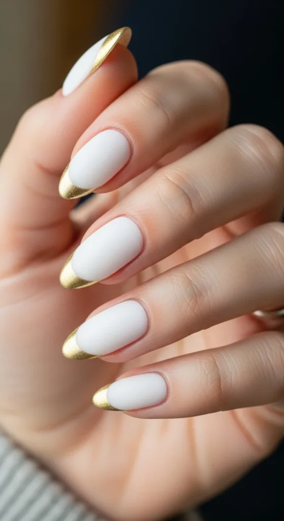 White frosted nails with gold chrome tips.
