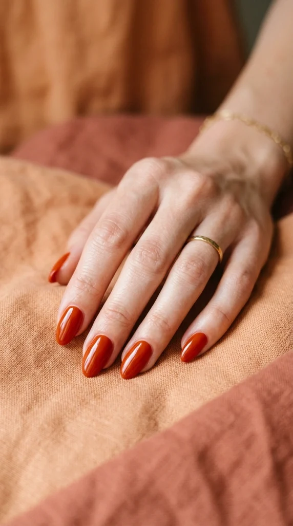 Summer Nail Colors 2026: 25 Trending Shades to Wear This Season 13 Rich blood orange almond nails with a glossy finish, a bold orange-red summer nail color trend for 2026.