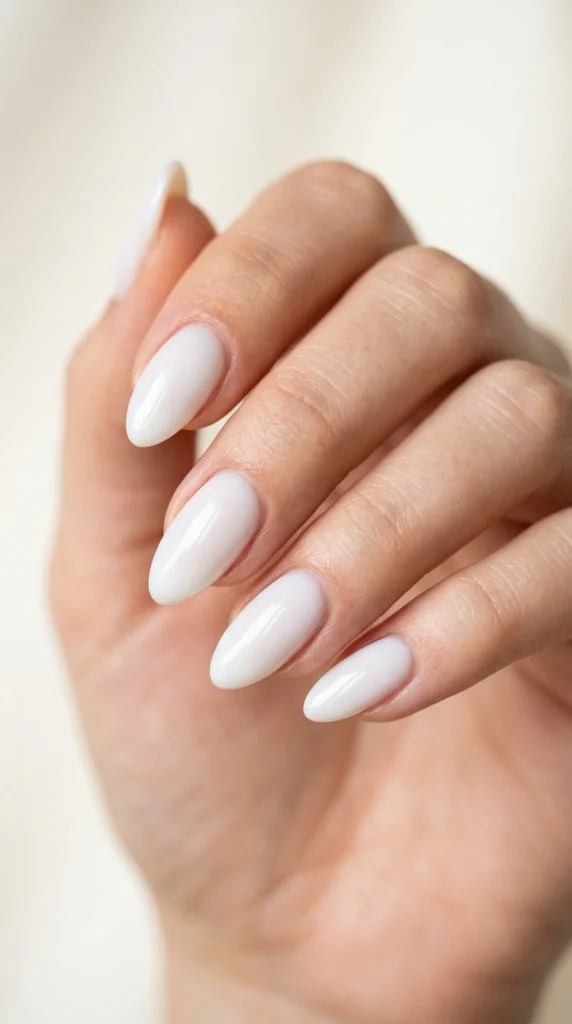 Summer Nail Colors 2026: 25 Trending Shades to Wear This Season 4 Milky cloud white almond nails with a glossy finish, a classy summer nail color trend for 2026