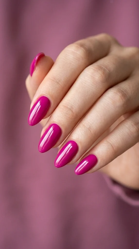 Summer Nail Colors 2026: 25 Trending Shades to Wear This Season 16 Bold fuchsia almond nails with a glossy finish, a vibrant pink-purple summer nail color trend for 2026.
