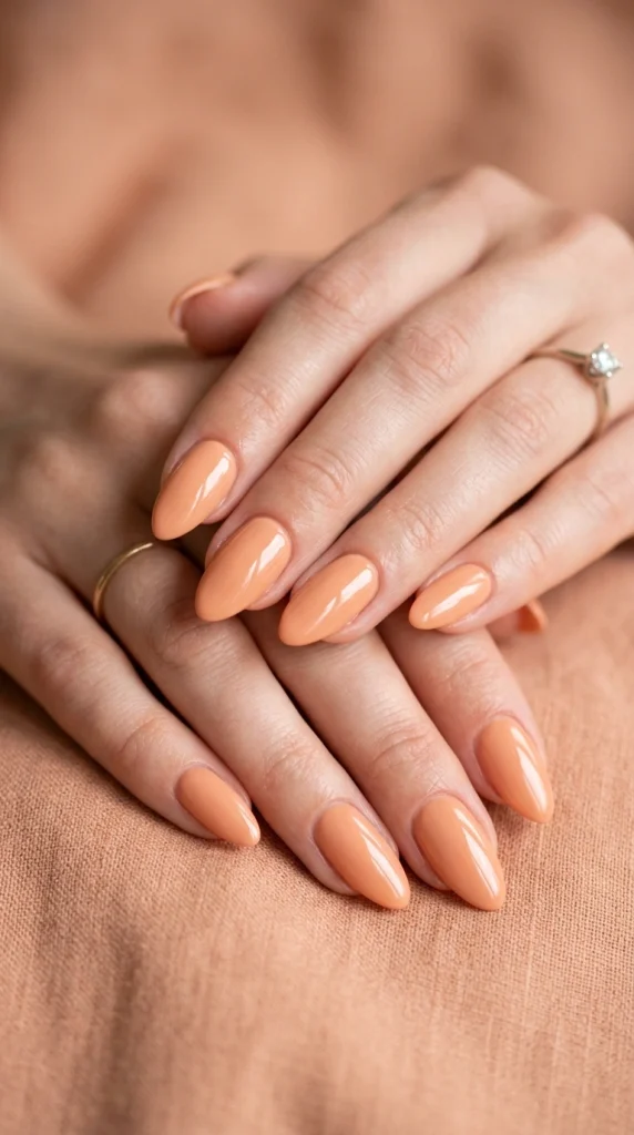 Summer Nail Colors 2026: 25 Trending Shades to Wear This Season 14 Soft peach almond nails with a glossy finish, a flattering peach summer nail color trend for 2026.
