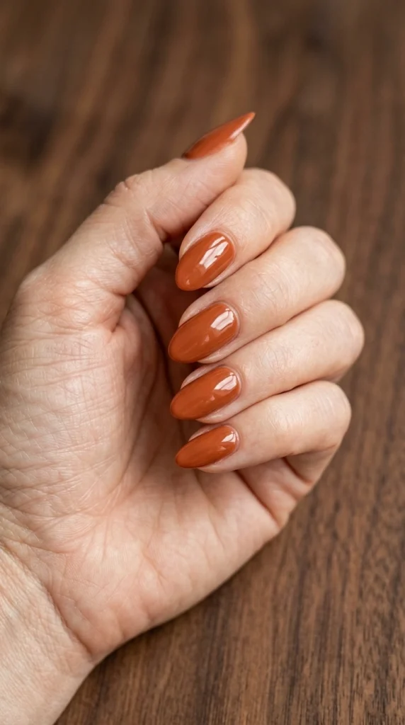 Summer Nail Colors 2026: 25 Trending Shades to Wear This Season 23 Rich persimmon orange-red almond nails with a glossy finish, a warm bold summer nail color trend for 2026.