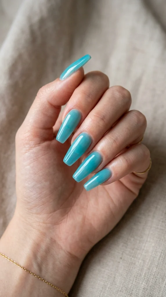 Summer Nail Colors 2026: 25 Trending Shades to Wear This Season 18 Translucent aqua blue almond nails with a glossy finish, a vacation-ready summer nail color trend for 2026.