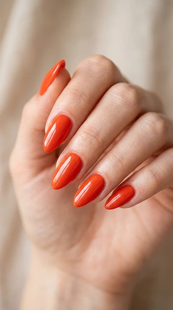 Summer Nail Colors 2026: 25 Trending Shades to Wear This Season 5 Glossy tomato red almond nails with a juicy jelly finish, a bold summer nail color trend for 2026.