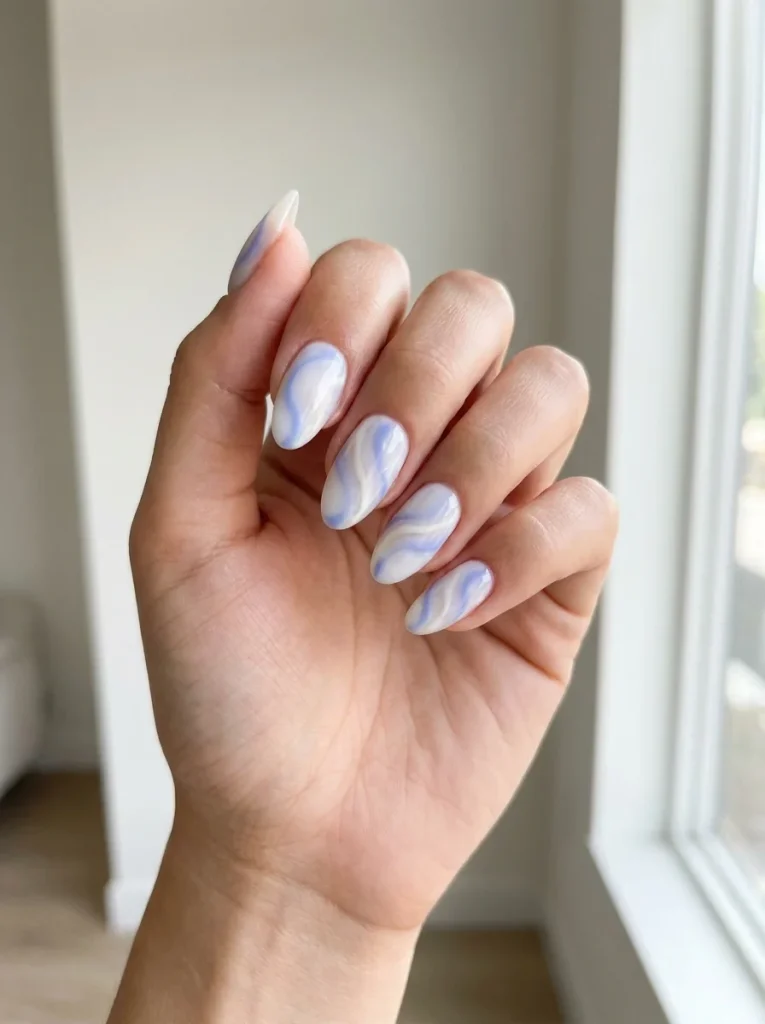 Blueberry Milk Swirls manicure with creamy white and pastel blue marble swirls on medium almond-shaped nails for a soft, elegant summer manicure.