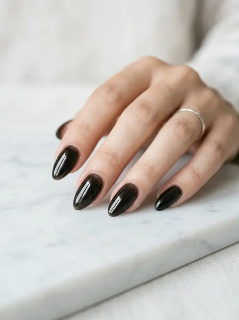 20 Chic September Nail Designs for 2026 That Capture Fall’s First Glow 17 Glossy black glass jelly almond nails with a translucent finish