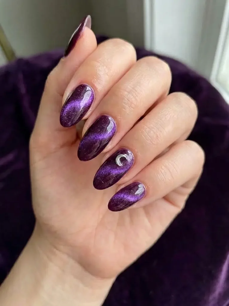 Witchy purple cat eye nails with violet magnetic shimmer and silver crescent moon accent