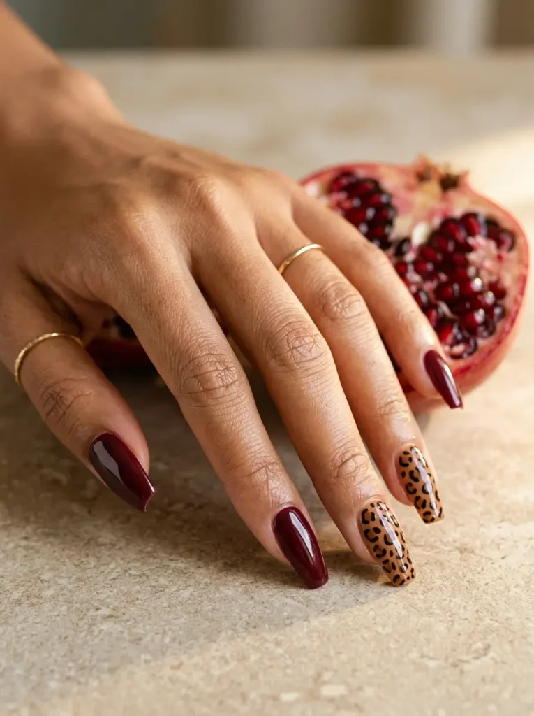 28 Fall Nail Designs for 2026, From Simple to Classy 29 Medium coffin glossy burgundy nails with a small leopard print on exactly two nails, on a tan skin tone
