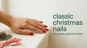 Short almond nails in classic Christmas red beside candy canes and a fir sprig on an ivory ledge