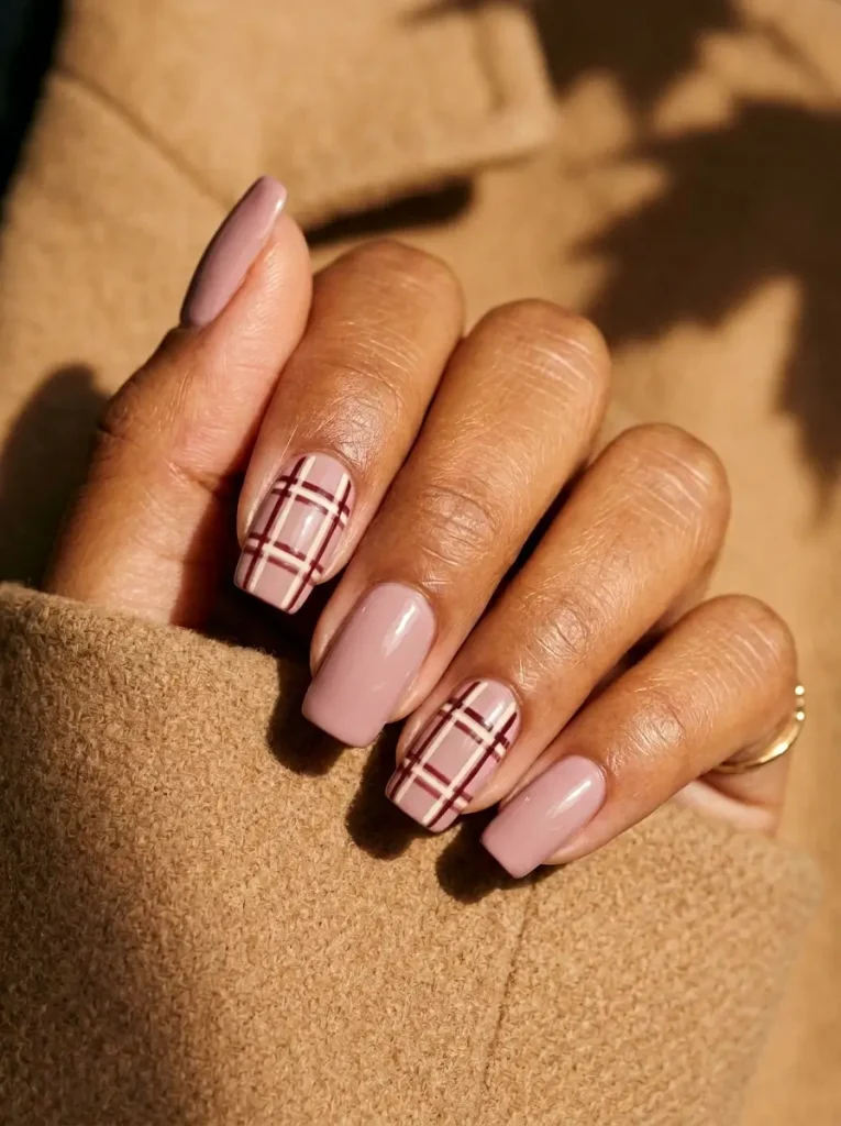 15 Pink Halloween Nail Designs for 2026, From Cute to Spooky 16 Squoval nails in dusty pink with cream and burgundy plaid on two nails, on a tan skin tone