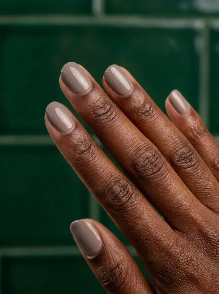 18 Fall Nail Colors for 2026, From Taupe to Navy 2 Mushroom taupe, a neutral among fall nail colors, on short glossy oval nails, on a deep skin tone