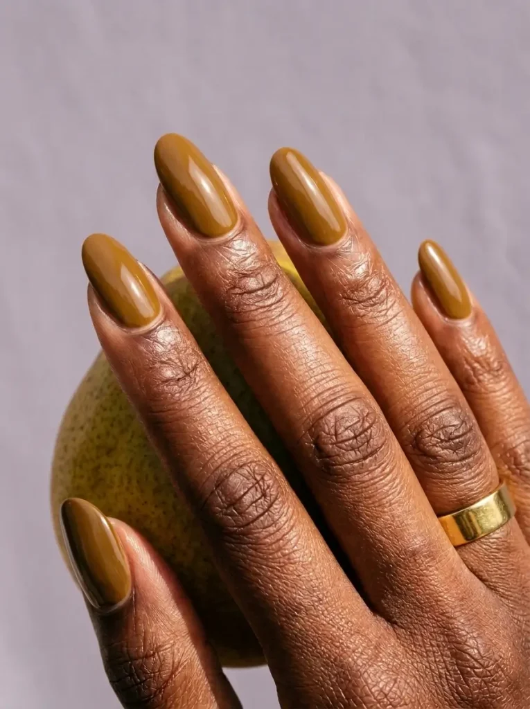 18 Fall Nail Colors for 2026, From Taupe to Navy 13 Mustard yellow glossy long oval nails, on a deep skin tone