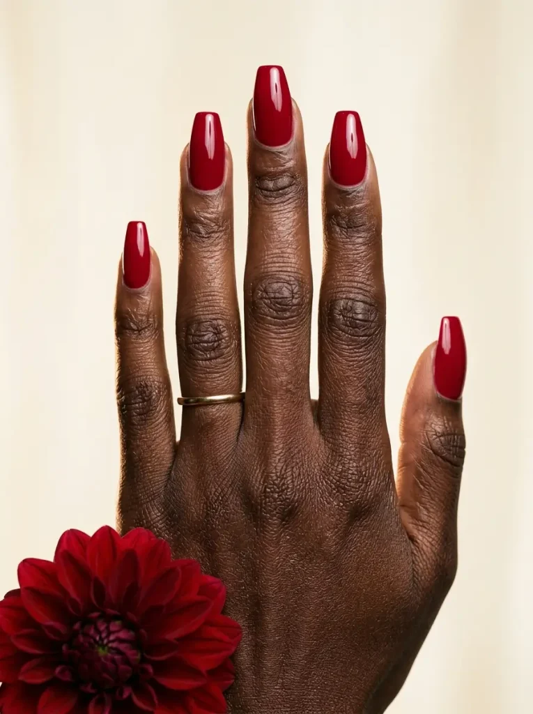 Coffin nails in glossy cherry red on a deep skin tone