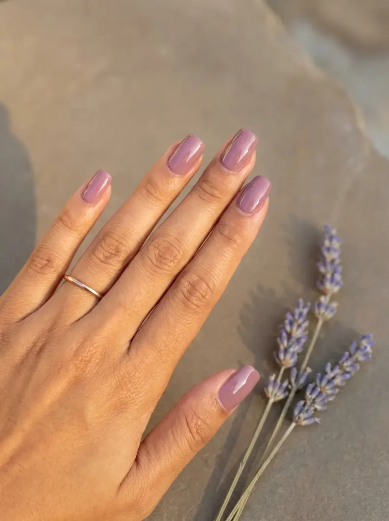 Squoval nails in glossy mauve on a medium skin tone