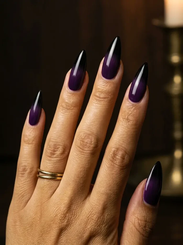 15 Witchy Nail Designs for 2026, From Gothic to Green Witch 2 Long stiletto nails with a glossy deep purple to black ombré fade, on a medium skin tone