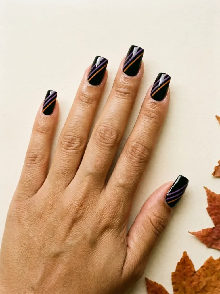 Medium square nails in black with thin diagonal purple and orange stripes, on a medium skin tone