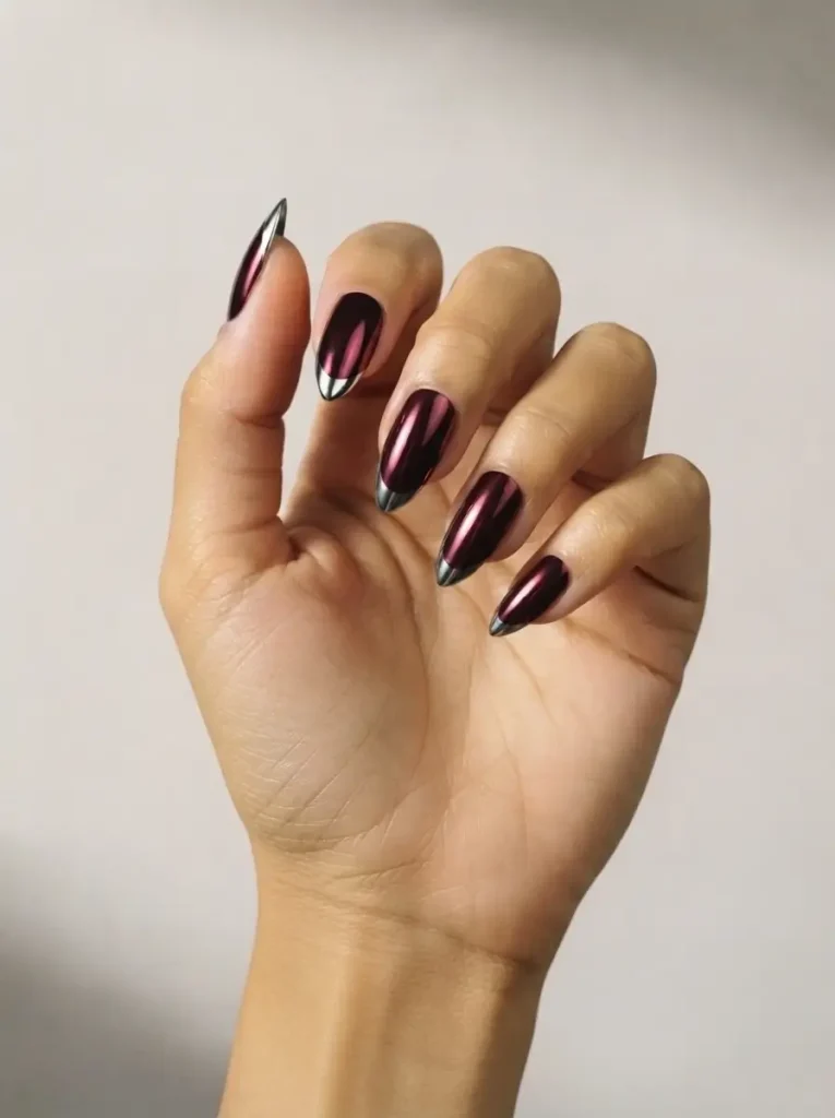 Long stiletto vampire nails in mirror red chrome with silver chrome claw tips on every point, on a medium skin tone