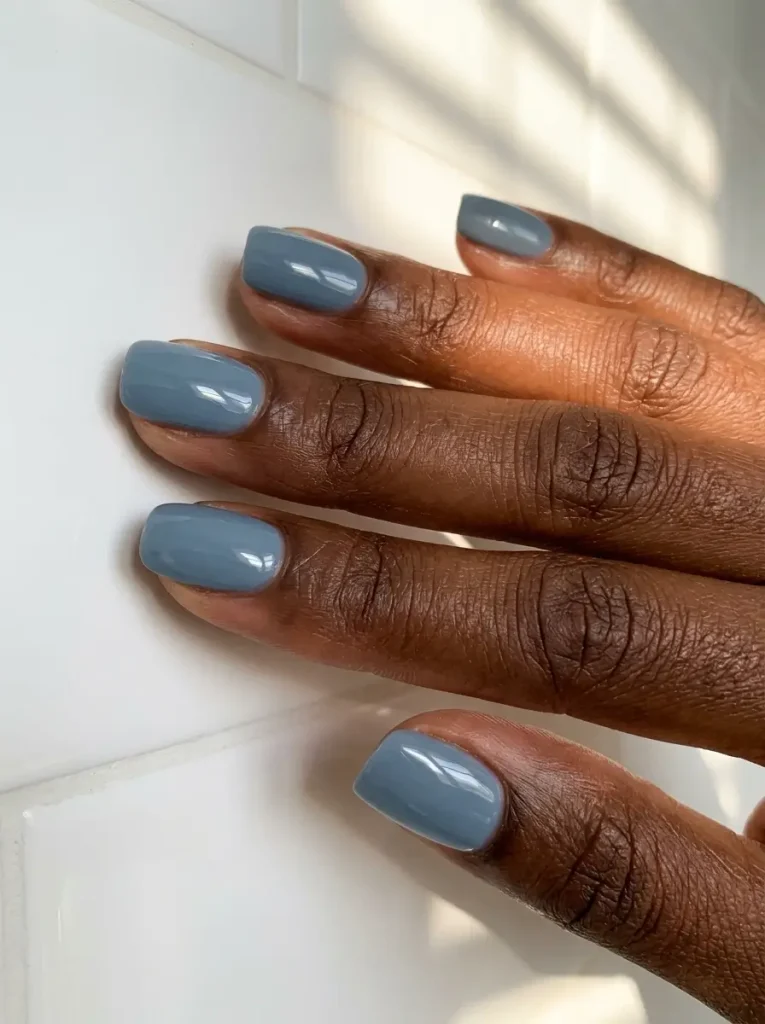 18 Fall Nail Colors for 2026, From Taupe to Navy 17 Smoky slate blue glossy short squoval nails, on a deep skin tone