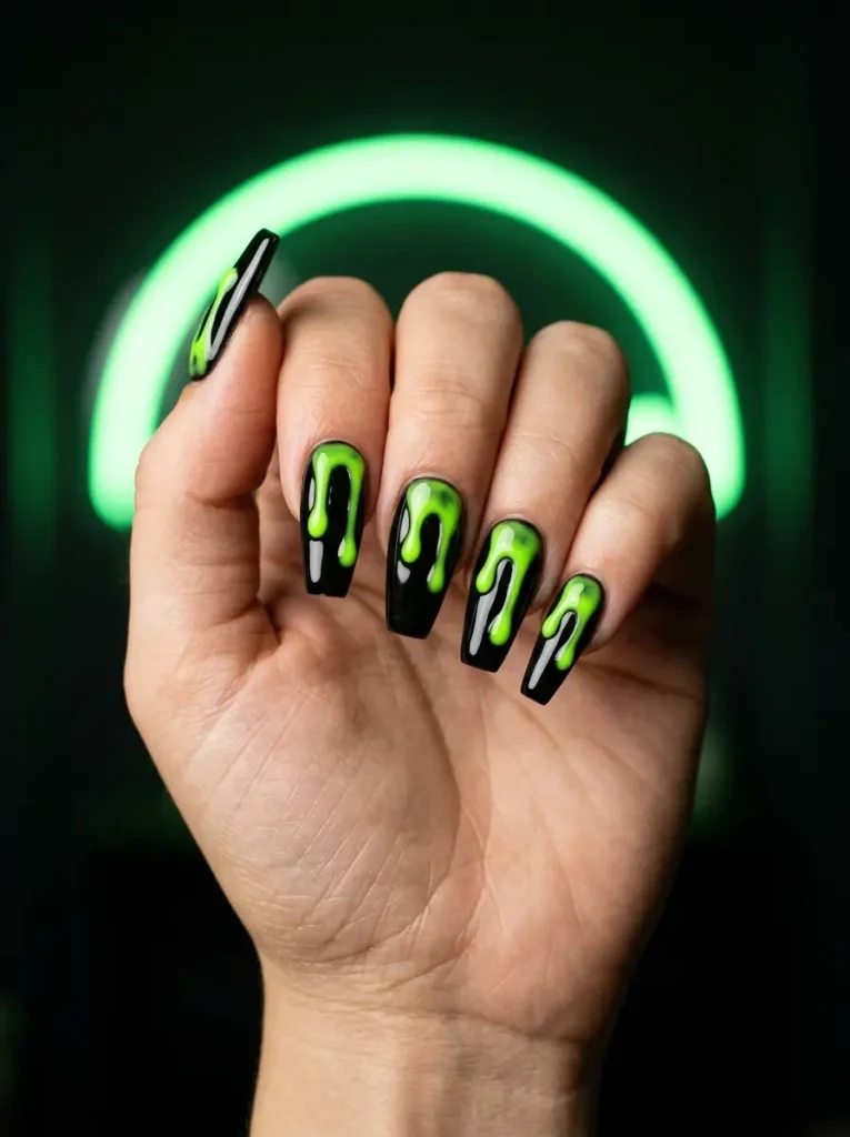 Black coffin nails with neon green slime dripping from the tips, on a light skin tone